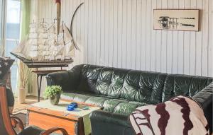 a living room with a green leather couch and a table at Nice Home In Gränna With House Sea View in Gränna +3 photos