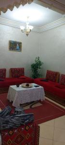 a living room with a table and red couches at Cozy in Midelt - Downtown apartment in Midelt +6 photos