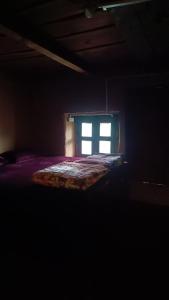 a bed in a dark room with a window at Roohi in Nagar