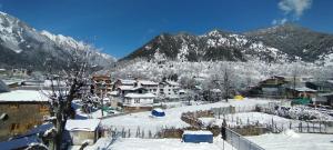 a town in the snow with mountains in the background at Tip Top Pahalgam in Pahalgām +9 photos