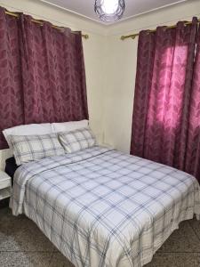 a bed in a room with purple curtains at Villa appartement jardin et piscine in Meknès +13 photos