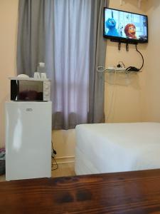 a living room with a microwave and a tv at Lisokhanya GuestHouse in East London