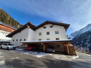 a building with two cars parked in front of it at Haus Gande in Spiss