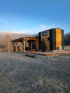 a house with a solarium in a field at Tiny House Barujec in Brenna