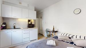 a kitchen with white cabinets and a bed in a room at Studio Fibra Gusto in Rybnik