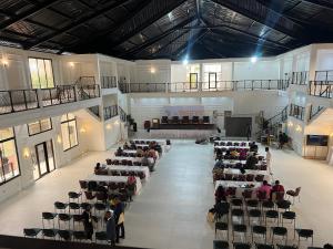 a group of people sitting in a large room with a stage at Marcsons Hotels and Resorts in Limbe