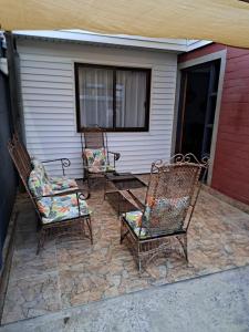 three chairs and a table on a patio at Acogedora casa para 6 personas en algarrobo in Algarrobo