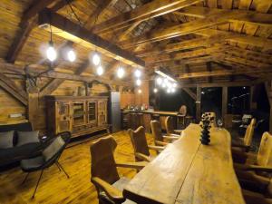 a large room with a wooden table and chairs at Wildglowlodge in Petroşani