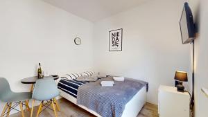 a bedroom with a bed and a table and a tv at Studio Fibra Gusto in Rybnik