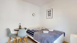 a bedroom with a bed and a table and chairs at Studio Fibra Gusto in Rybnik