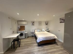 a bedroom with a bed and a desk in it at Cosy, self-contained guest house in Thornton Heath