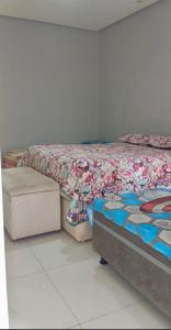 a bedroom with a bed with a comforter on it at Recanto da Lú Casa - Salvador in Salvador