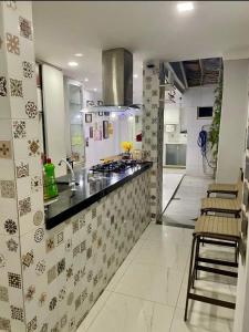 a kitchen with a sink and a counter with chairs at Recanto da Lú Casa - Salvador in Salvador +16 photos