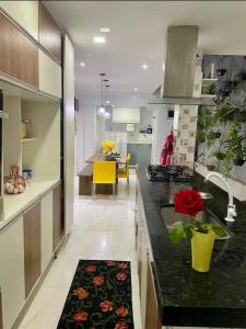a kitchen with a black counter top and a table at Recanto da Lú Casa - Salvador in Salvador