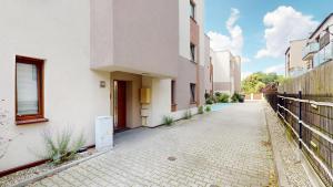 an empty street next to a white building at Studio Fibra Gusto in Rybnik