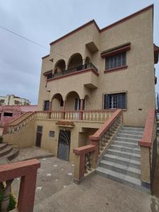 a large building with stairs and a balcony at Villa appartement jardin et piscine in Meknès