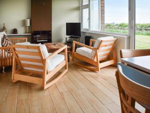 a living room with two chairs and a table at Eastcliff Bungalow in Mundesley