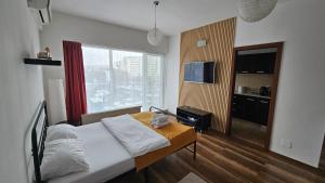 a hotel room with a bed and a window at Luca Apartament in Bucharest