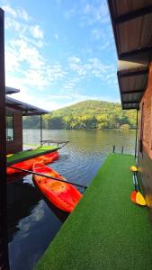a group of canoes on the water next to a building at แพบ้านแม่ in Ban Tha Ta On
