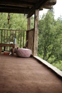 a porch with a bench and a red and white pillow at Roohi in Nagar