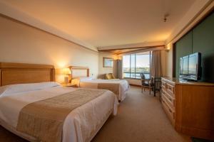 ein Hotelzimmer mit zwei Betten und einem Flachbildfernseher in der Unterkunft Hotel Marina Villa del Rio in Valdivia + 49 Fotos