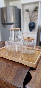 two wine glasses on a wooden tray on a table at Cozy 1Bedroom House with Kitchen Work Space in Nusa Dua