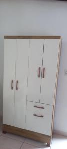 a wardrobe with white doors and a wooden frame at Espaço da paz in Joinville