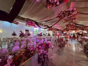 a room filled with tables and chairs with pink flowers at Marcsons Hotels and Resorts in Limbe +61 photos