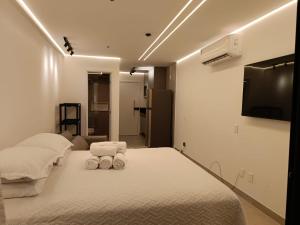 a bedroom with two beds and a flat screen tv at Beach Class Verano Flat 216 C in Porto De Galinhas +20 photos