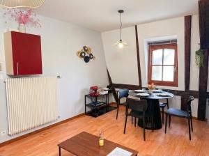 a living room with a table and a dining room at Le Cocon Alsacien au cœur de Rouffach in Rouffach