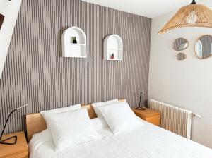a bedroom with a bed and a striped wall at Le Cocon Alsacien au cœur de Rouffach in Rouffach