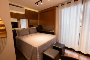 a small bedroom with a bed and a window at Flat Exclusivo studio cuiaba 702 in Cuiabá