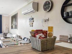 a dining room with a table and a clock on the wall at The Stables in Edmondsham +10 photos