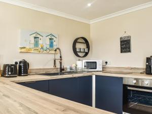 a kitchen with a counter top with a sink and a microwave at The Stables in Edmondsham