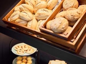 a bunch of different types of bread in trays at B&B Hotel Böblingen in Böblingen