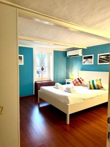 a bedroom with a large bed with blue walls at Cà Allungata by Gottschalk in Dorio