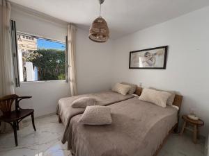 two beds in a white room with a window at Casa MaJa in Denia +33 photos