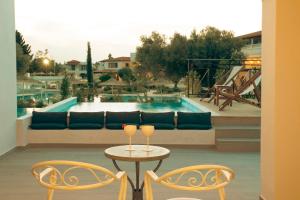 a patio with a table and two chairs and a couch at Zeus Eretria Resort in Eretria