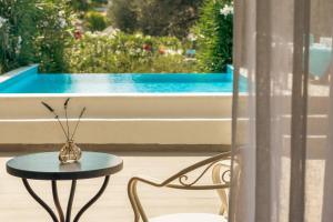 a table and chair next to a window with a pool at Zeus Eretria Resort in Eretria +134 photos