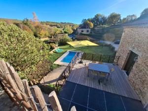 a deck with a table and chairs and a swimming pool at Les Mas d Olema in Puy-lʼÉvêque