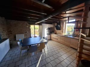 a kitchen with a table and chairs in a room at Les Mas d Olema in Puy-lʼÉvêque