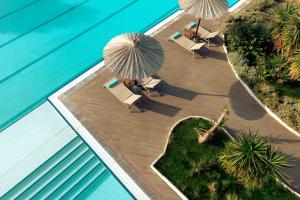 an overhead view of a swimming pool with chairs and umbrellas at Zeus Eretria Resort in Eretria