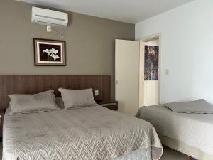 a bedroom with two beds and a air conditioner at Refúgio Escarpas do Lago Mirante 1702 in Capitólio +25 photos