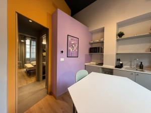a kitchen with a white table and a purple wall at THE DESIGNER HIDE OUT - Casa Vacanze in Turin
