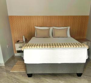 a bedroom with a large bed with two pillows at Marble Crest Guest House in Maun