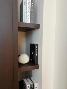a book shelf with books and a vase on it at Hôtel Royal Beaulaincourt in Béthune
