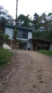 a house with a dirt road in front of it at Casa Maria Rosa Quarto 1 in Blumenau