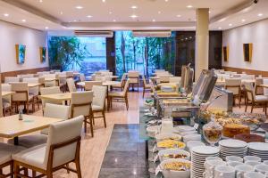 a restaurant with tables and chairs and food on display at South American Copacabana Hotel in Rio de Janeiro