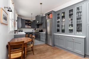 a kitchen with gray cabinets and a wooden table at Les Jardins du Panthéon in Paris