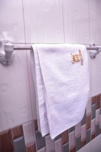 a white towel hanging on a towel rack in a bathroom at lynna hôtel in Yaoundé +100 photos